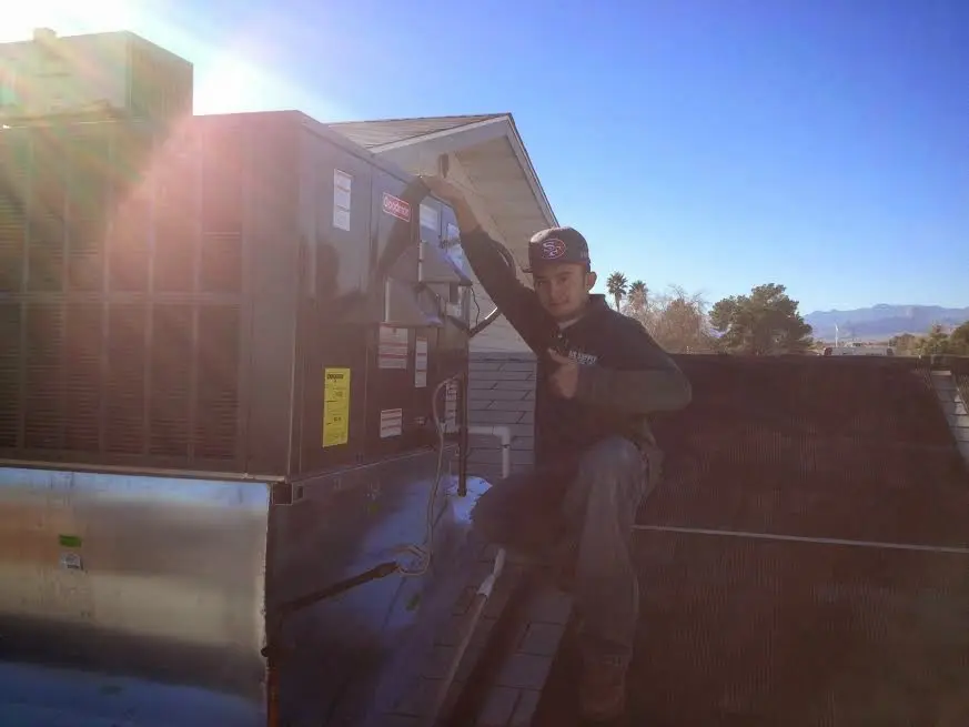 HVAC technician performing AC Tune-Up on a rooftop unit in Fremont