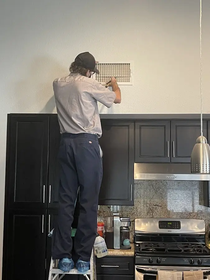 Technician inspecting an air vent during HVAC service in Fremont